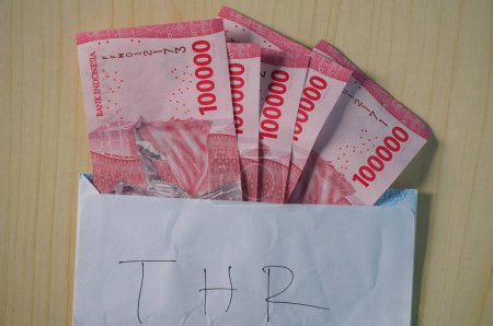 Indonesian Rupiah money on a white envelope. Uang 100.000 Rupiah, IDR 100.000, THR on Eid al-Fitr or Eid days
