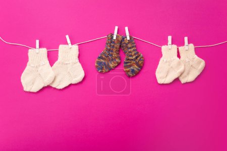 Photo for World Prematurity day concept. Normal size and Tiny socks on rope with pink background. - Royalty Free Image