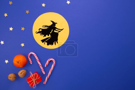 Epiphany day tradition.Witch Befana flying on broomstick on dark blue background. Candy, nuts, gifts.
