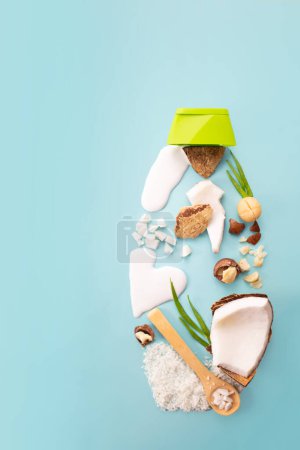 Téléchargez les photos : Noix de macadamia, noix de coco, farine de coco et lait sur fond bleu. Conception du produit. Des ingrédients cosmétiques naturels. Vue du dessus - en image libre de droit