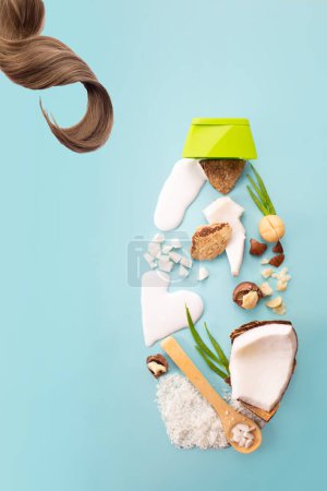 Téléchargez les photos : Cheveux, noix de macadamia, noix de coco, farine de noix de coco et lait sur fond bleu. Conception du produit. Des ingrédients cosmétiques naturels. Vue du dessus - en image libre de droit