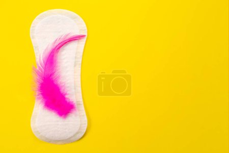 Blood and feminine hygiene pad with red glitter on pink background. First menstrual period concept.