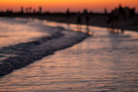 Beach sunset concept. Abstract beach Beautiful blurred sunset sky. blurring seaside on twilight cloud, sunrise warm sunlight. Defocused landscape of sand, sea, wave