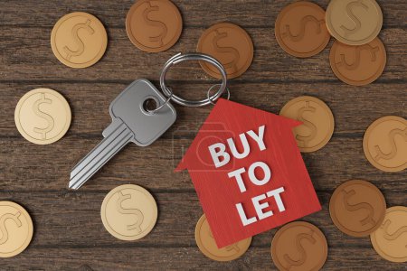 Silver door key and a red house shaped key ring having the white phase BUY TO LET on a heap of golden coins on wooden table. Illustration of the concept of landlords and property rental business