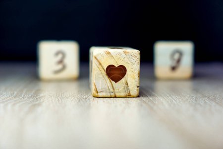 Téléchargez les photos : Symboles coeur de fin de grossesse âge jalon écrit sur un cube en bois avec un fond noir - en image libre de droit