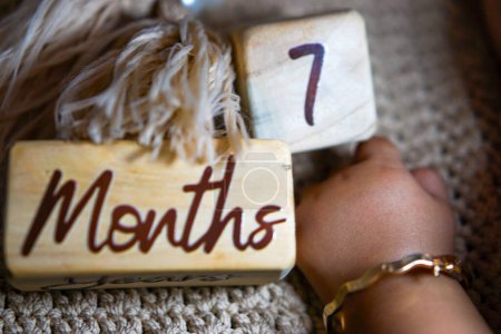Foto de Milestone bebé de 7 meses escrito en un cubo de madera - Imagen libre de derechos