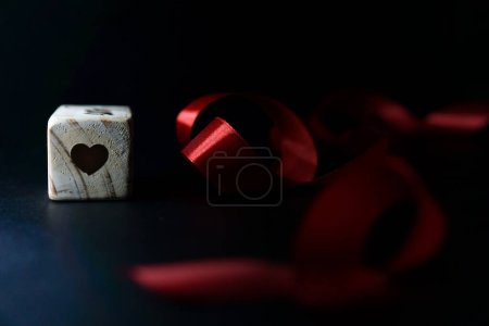 Téléchargez les photos : Jalon de l'âge du bébé écrit sur un cube en bois avec un ruban rouge sur un fond noir - en image libre de droit