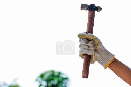 Die Hände tragen Handschuhe mit einem Hammer im Hintergrund, fröhlicher Arbeitstag. Internationale Feier.