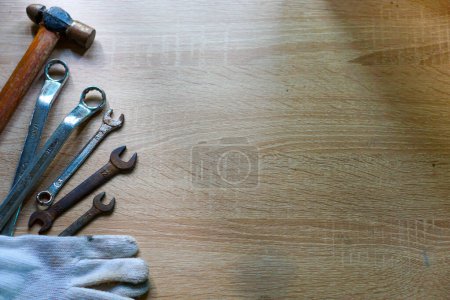 Schraubenschlüssel, Ringschlüssel, Hammer, Handschuhe auf dem Tisch. Konzept Internationaler Tag der Arbeit