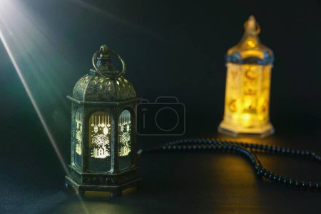 Ramadan Kareem Grußfoto mit schwarzem Hintergrund und ruhigem Licht mit schön leuchtenden Laternen.