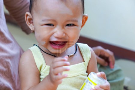 Porträt eines asiatischen Mädchens, das lacht und seinen ersten Zahn zeigt