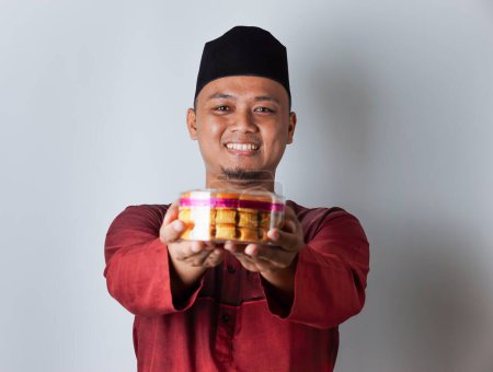 Porträt eines asiatischen muslimischen Mannes mit nastar-Keksen