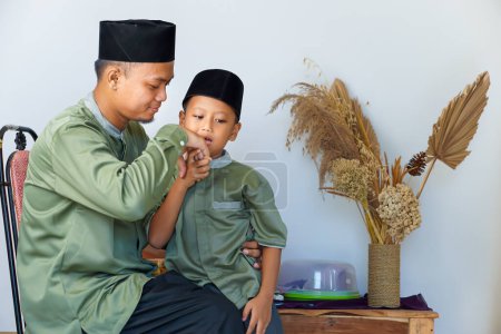 Porträt eines muslimischen Kindes, das seinem Vater nach dem Eid-Fest die Hand küsst. Eid-Konzept