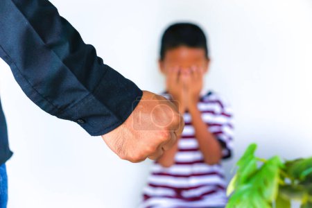 Photo for Violence against children. Cropped of man clenching his fists in anger, a small child crying and covering his face with his hands in the background. - Royalty Free Image