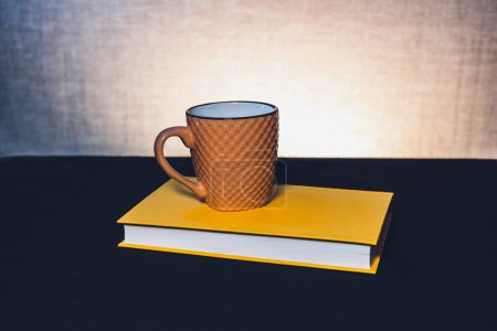 Photo for Mug with a book the theme of learning or creating a postcard - Royalty Free Image