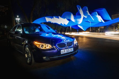 Téléchargez les photos : Tachkent, Ouzbékistan - 22 mars 2023 : BMW marque de voiture dans la ville dans un éclairage intéressant - en image libre de droit