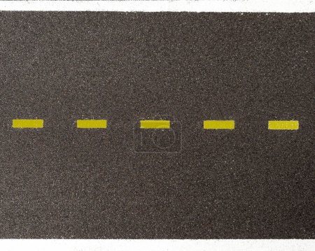 Vue aérienne de l'asphalte avec une ligne de démarcation en pointillés jaunes et des lignes continues blanches délimitant la route