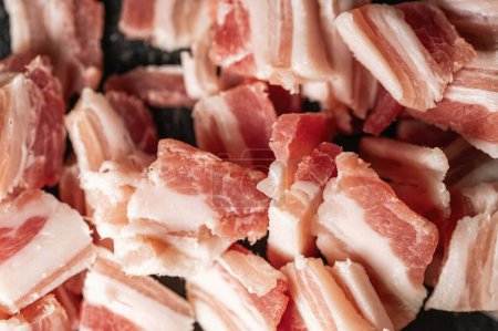 Pieces of pork belly cut into pieces to cook a dish such as spaghetti carbonara creating a background