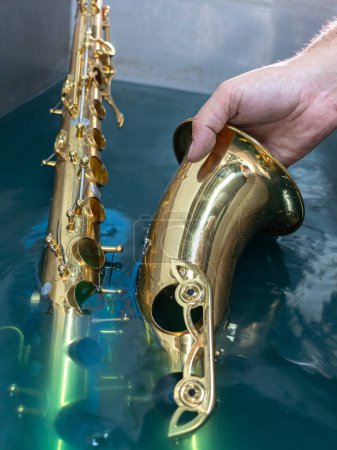 Foto de Sumergir un saxofón para limpiar - Imagen libre de derechos