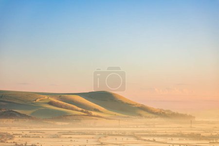 Photo for Misty morning December sunrise over mount Caburn from Kingston Ridge on the south downs east Sussex south east England - Royalty Free Image