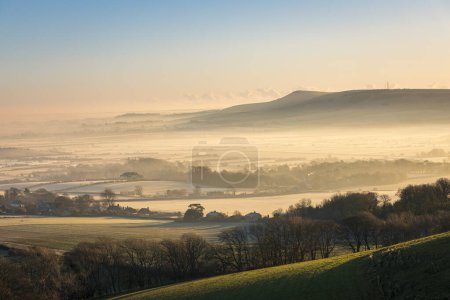Photo for Misty morning December sunrise over mount Caburn from Kingston Ridge on the south downs east Sussex south east England - Royalty Free Image