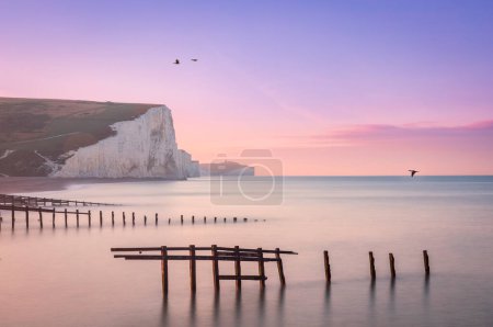 Téléchargez les photos : Lever de soleil du ciel lilas à marée haute à Cuckmere Haven et les falaises Seven Sisters sur la côte est du Sussex sud-est de l'Angleterre Royaume-Uni - en image libre de droit