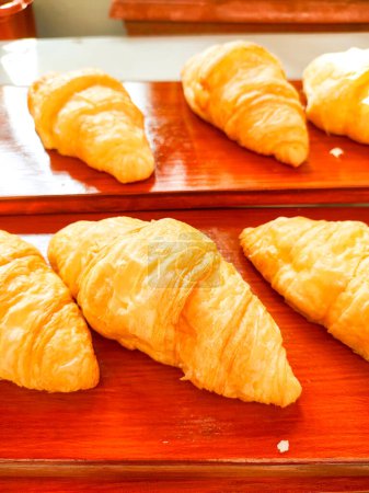 Croissant cake looks delicious, tender and crispy as a complement to morning meal. Served on a wooden tray.