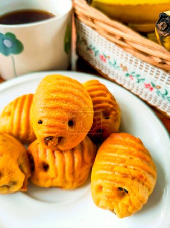 Gendu cake from Blora, Indonesia, is similar to pineapple tart with pineapple or durian filling. Shaped like a teak tree caterpillar. As a snack for tea time. Served on a white plate.