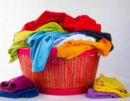 Téléchargez les photos : Une image capturant un panier débordant dédié à la lessive, symbolisant une tâche ménagère commune, sur fond blanc - en image libre de droit