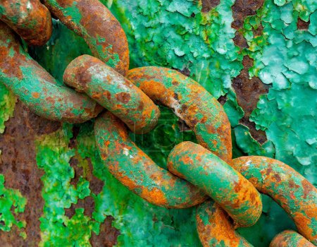 Close-up of a rusty and weathered metal chain with green paint, highlighting texture contrast