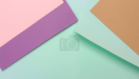 Feuilles de papier colorées disposées en palette pastel pour un fond créatif