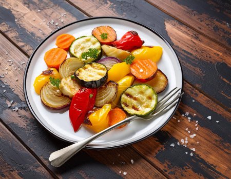 Colorful roasted vegetables on dark wooden background from above