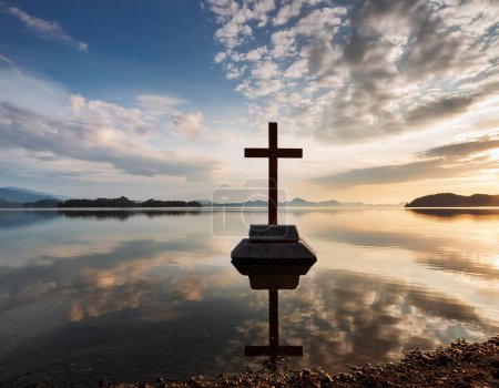 Una escena serena de una cruz de pie sobre un lago tranquilo con un hermoso fondo de cielo