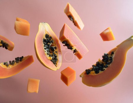 Abstrakte Darstellung von geschnittenen und frei schwebenden Papayastücken, die negativen Raum nutzen