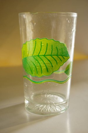 Foto de Una taza de vidrio con un motivo floral verde con un fondo que lo aísla - Imagen libre de derechos