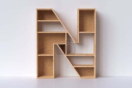Photo for 3D wooden letter N shaped like furniture, designed to display books or small decorative items. 3D rendering - Royalty Free Image