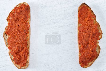 Téléchargez les photos : Deux tranches de pain mallorcan avec de la viande mallorcan typique propagation Sobrasada. Vue de dessus sur fond clair avec espace vide au centre - en image libre de droit