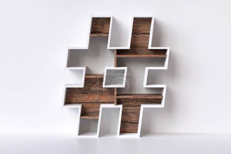 Téléchargez les photos : Symbole de hashtag en bois sous la forme de meubles avec étagères en bois brut. Mobilier et design d'intérieur concepts de médias sociaux. rendu 3D. - en image libre de droit