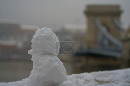 Photo for Budapest, Hungary - November 30, 2023: Snowman with the Chain bridge on the background. - Royalty Free Image