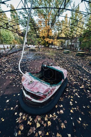 Foto de Viaje en coche de atracciones abandonadas en la ciudad fantasma de Pripyat en la zona de exclusión de Chernobyl, scooter en colores de otoño - Imagen libre de derechos