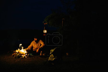 Téléchargez les photos : Un voyageur cuisine des œufs frits sur un feu de joie. Le concept de voyage et de survie dans la nature. - en image libre de droit