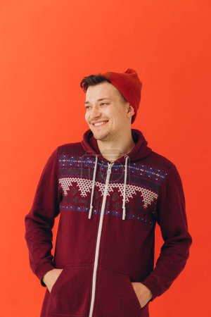 Photo for Young man in Christmas sweater and hat on color backgroun - Royalty Free Image