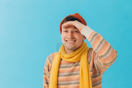 Photo for Handsome young man in winter clothes on color backgroun - Royalty Free Image