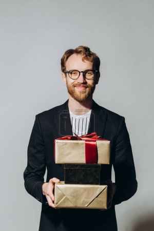 Photo for Celebration Time. Portrait of a happy guy holding stack of present boxes isolated over white background at studio. - Royalty Free Image