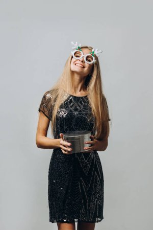 Photo for Merry Christmas: a Happy Blonde Woman in a Festive Dress Holding Christmas Presents. Portrait - stock photo - Royalty Free Image