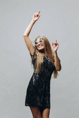 Téléchargez les photos : C'est l'heure des fêtes. Belle femme souriante dansant, douchée de confettis. - en image libre de droit