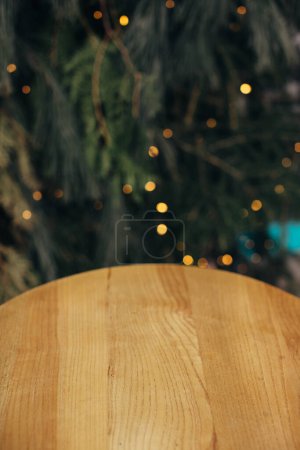 Foto de Fondo de Navidad, mesa de madera y ramas de pino con luces de guirnalda. - Imagen libre de derechos