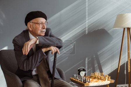 Téléchargez les photos : Portrait de vieil homme sérieux jouant aux échecs en roo - en image libre de droit