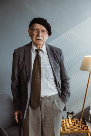 Téléchargez les photos : Portrait d'un vieil homme aux cheveux gris avec un bâton dans les mains. - en image libre de droit