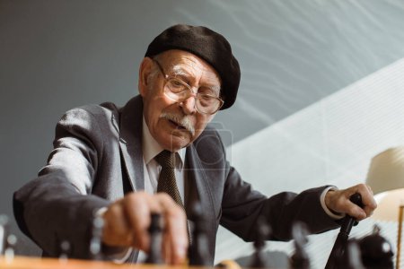 Foto de Retrato de un viejo serio jugando al ajedrez en roo - Imagen libre de derechos